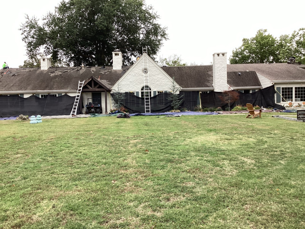 Catch-All netting and tarps protecting a large home and its landscaping during a roof tear-off