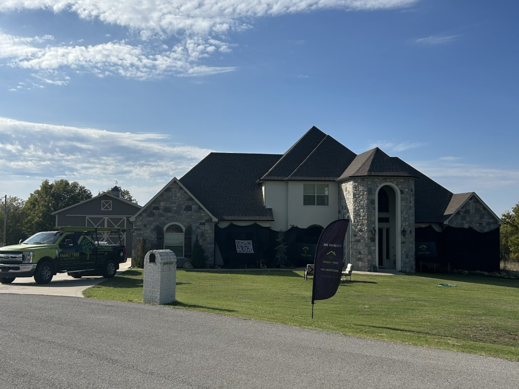 Family Tree Roofing truck and Catch-All protection around a stone home during a roof replacement in Collinsville
