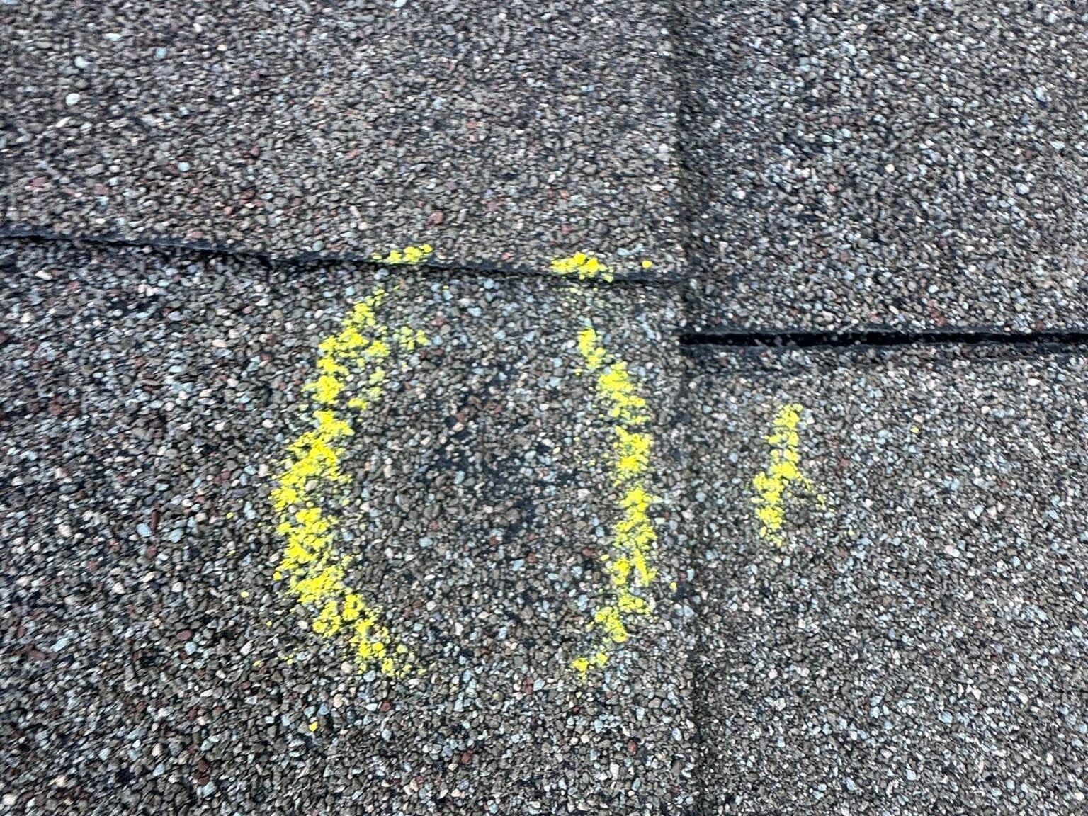 Hail impact marked on a shingle during an inspection
