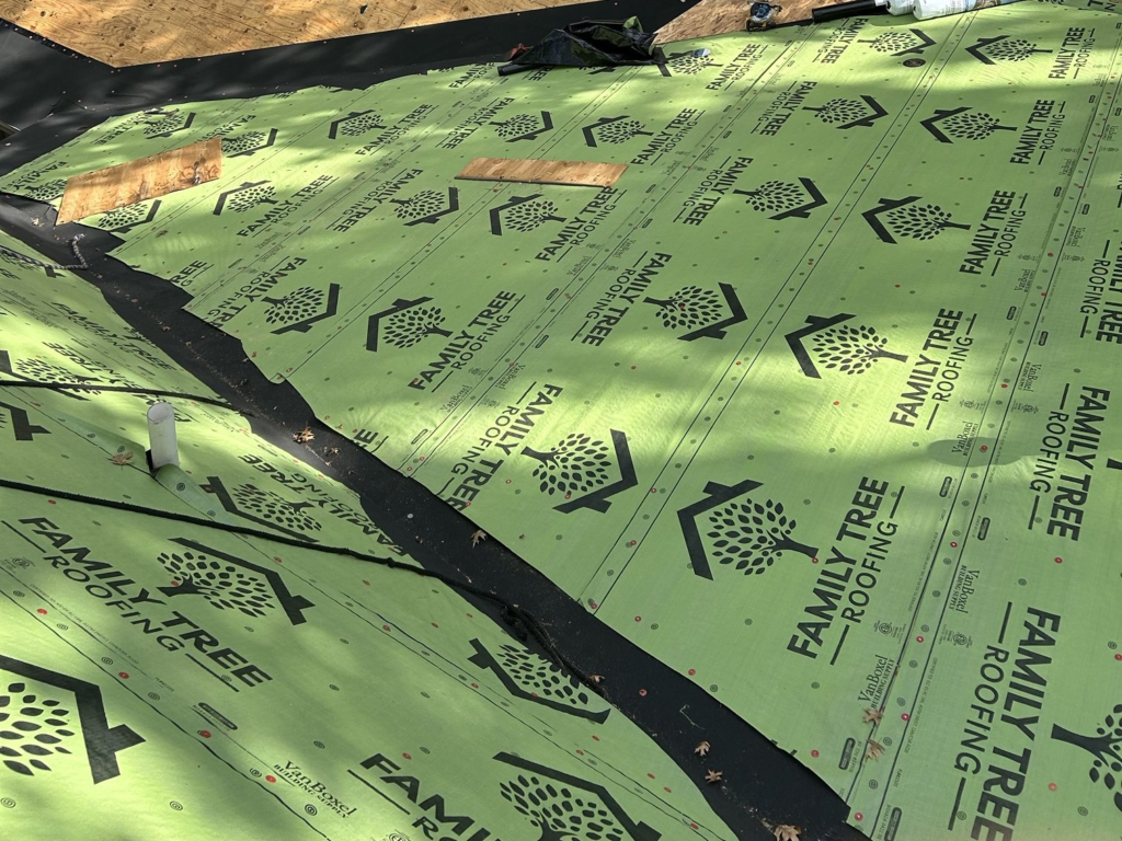 Roof valley lined with black ice-and-water shield beside Family Tree Roofing branded synthetic underlayment during a roof replacement