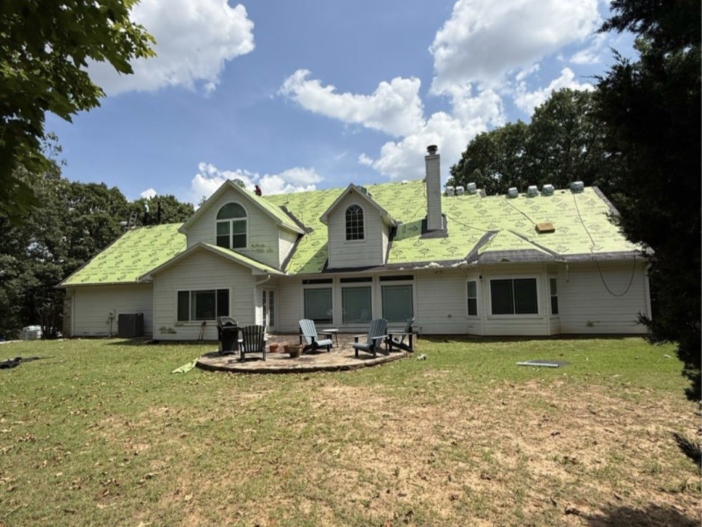Synthetic underlayment covering the roof deck of a two-story home in Sand Springs during a roof replacement